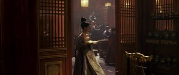 Movie still from “Curse of the Golden Flower” (2006), directed by Yimou Zhang – A woman in traditional chinese clothing holding a plate; Wide shot, Over the shoulder angle
