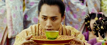 Movie still from “Curse of the Golden Flower” (2006), directed by Yimou Zhang – A man in oriental garb drinking a cup of tea; Close Up shot, Low angle
