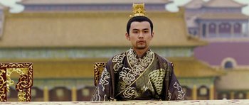 Movie still from “Curse of the Golden Flower” (2006), directed by Yimou Zhang – A man wearing a gold crown sitting in a chair; Close Up shot, Low angle