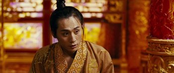 Movie still from “Curse of the Golden Flower” (2006), directed by Yimou Zhang – A man in a robe with a bun on top of his head; Close Up shot, Over the shoulder angle