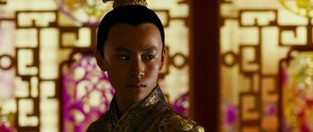 Movie still from “Curse of the Golden Flower” (2006), directed by Yimou Zhang – A young man in a gold and black outfit; Close Up shot, Low angle
