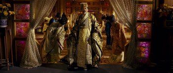 Movie still from “Curse of the Golden Flower” (2006), directed by Yimou Zhang – A man dressed as a chinese emperor stands in front of a group of people; Wide shot, Low angle