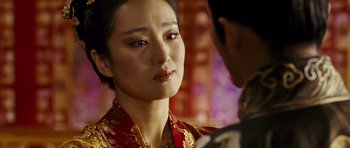 Movie still from “Curse of the Golden Flower” (2006), directed by Yimou Zhang – A person wearing a red and gold dress; Close Up shot, Over the shoulder angle