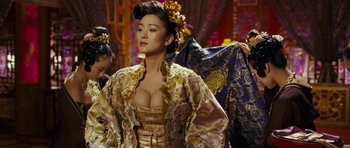 Movie still from “Curse of the Golden Flower” (2006), directed by Yimou Zhang – A woman in a gold and purple dress; Medium shot, Over the shoulder angle
