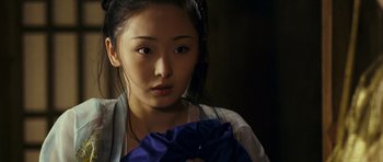 Movie still from “Curse of the Golden Flower” (2006), directed by Yimou Zhang – A young asian woman holding a blue cloth; Close Up shot, Over the shoulder angle