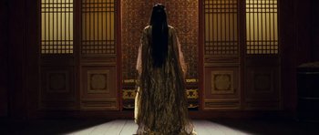 Movie still from “Curse of the Golden Flower” (2006), directed by Yimou Zhang – A woman standing in front of an ornate door; Medium shot, Low angle