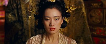 Movie still from “Curse of the Golden Flower” (2006), directed by Yimou Zhang – A woman in a gold and pink dress with a black hair style; Close Up shot, Overhead angle