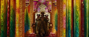 Movie still from “Curse of the Golden Flower” (2006), directed by Yimou Zhang – Three women dressed up in elaborate costumes in front of stained glass; Extreme Wide shot, Low angle