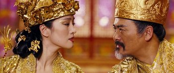 Movie still from “Curse of the Golden Flower” (2006), directed by Yimou Zhang – A man and a woman in gold headpieces; Close Up shot, Over the shoulder angle
