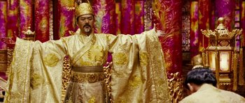 Movie still from “Curse of the Golden Flower” (2006), directed by Yimou Zhang – A man dressed in a gold outfit and a gold hat; Medium shot, Low angle