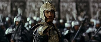 Movie still from “Curse of the Golden Flower” (2006), directed by Yimou Zhang – A man wearing a helmet and holding a gun; Close Up shot, Over the shoulder angle