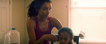 Movie still from “Cut Throat City” (2020), directed by RZA – A young woman is combing the hair of a young girl; Close Up shot, Over the shoulder angle