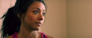 Movie still from “Cut Throat City” (2020), directed by RZA – A woman's face in a pink shirt; Close Up shot, Over the shoulder angle