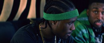 Movie still from “Cut Throat City” (2020), directed by RZA – A person wearing a headband; Close Up shot, Over the shoulder angle