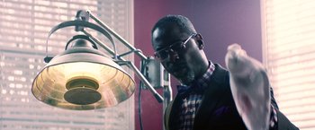 Movie still from “Cut Throat City” (2020), directed by RZA – A man standing in front of a light; Close Up shot, Low angle