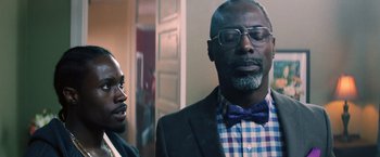 Movie still from “Cut Throat City” (2020), directed by RZA – A man in a suit and a bow tie standing next to another man; Close Up shot, Over the shoulder angle
