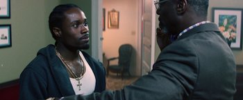 Movie still from “Cut Throat City” (2020), directed by RZA – Two men are talking in a living room; Close Up shot, Over the shoulder angle