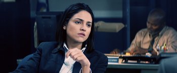 Movie still from “Cut Throat City” (2020), directed by RZA – A woman sitting in a chair in front of a computer monitor; Close Up shot, Over the shoulder angle