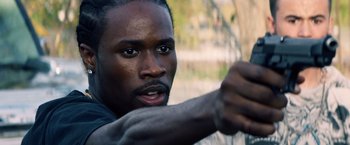 Movie still from “Cut Throat City” (2020), directed by RZA – A person with a fist up; Close Up shot, Over the shoulder angle