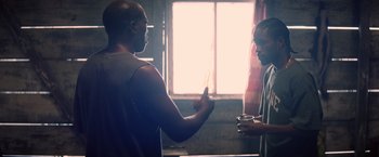 Movie still from “Cut Throat City” (2020), directed by RZA – Two men are standing in front of a window and one is holding a cup of coffee; Medium shot, Over the shoulder angle