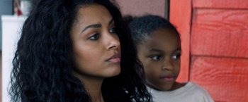 Movie still from “Cut Throat City” (2020), directed by RZA – A woman and a child looking at the camera; Close Up shot, Over the shoulder angle
