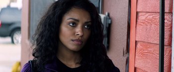 Movie still from “Cut Throat City” (2020), directed by RZA – A person with long black curly hair; Close Up shot, Over the shoulder angle