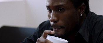 Movie still from “Cut Throat City” (2020), directed by RZA – A person holding a cup of coffee; Close Up shot, High angle