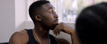 Movie still from “Cut Throat City” (2020), directed by RZA – A man with his chin resting on his hand; Close Up shot, Over the shoulder angle