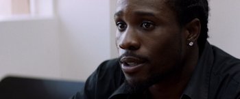 Movie still from “Cut Throat City” (2020), directed by RZA – A person wearing a black shirt; Close Up shot, Over the shoulder angle