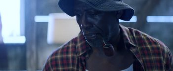 Movie still from “Cut Throat City” (2020), directed by RZA – A person with a pipe in his mouth; Close Up shot, Low angle