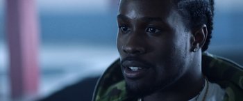 Movie still from “Cut Throat City” (2020), directed by RZA – A man's face in a dark room; Close Up shot, Over the shoulder angle