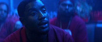 Movie still from “Cut Throat City” (2020), directed by RZA – A man in a purple shirt is looking at the camera; Close Up shot, Over the shoulder angle