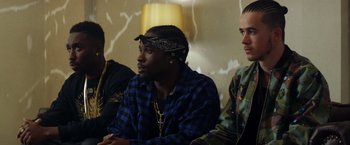 Movie still from “Cut Throat City” (2020), directed by RZA – A group of men sitting next to each other in a room; Medium shot, Over the shoulder angle