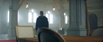 Movie still from “Cut Throat City” (2020), directed by RZA – A man standing in front of a window in a room; Wide shot, Low angle
