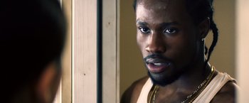 Movie still from “Cut Throat City” (2020), directed by RZA – A person with a beard looking at the camera; Close Up shot, Over the shoulder angle