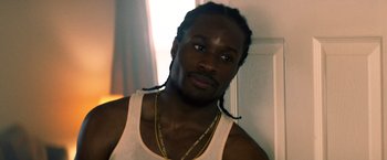 Movie still from “Cut Throat City” (2020), directed by RZA – A person wearing a white tank top; Close Up shot, Over the shoulder angle