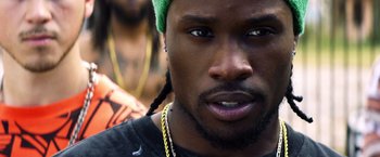 Movie still from “Cut Throat City” (2020), directed by RZA – A person wearing a green hat; Close Up shot, Over the shoulder angle