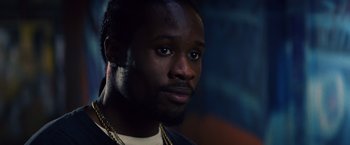 Movie still from “Cut Throat City” (2020), directed by RZA – A person wearing a necklace; Close Up shot, Low angle