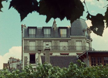 Movie still from “Celine and Julie Go Boating” (1974), directed by Jacques Rivette – An old building in the middle of a leafy green area; Extreme Wide shot, Low angle