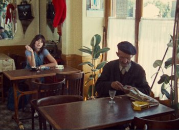 Movie still from “Celine and Julie Go Boating” (1974), directed by Jacques Rivette – An older man sitting at a table in a restaurant; Wide shot, Over the shoulder angle