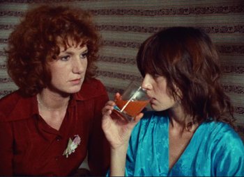 Movie still from “Celine and Julie Go Boating” (1974), directed by Jacques Rivette – Two women are drinking orange juice from a glass; Close Up shot, High angle