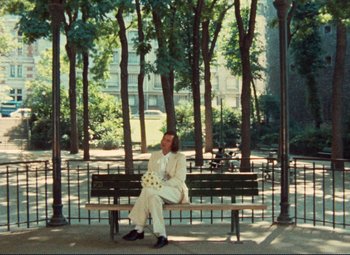 Movie still from “Celine and Julie Go Boating” (1974), directed by Jacques Rivette – A man sitting on top of a wooden park bench; Wide shot, High angle