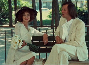 Movie still from “Celine and Julie Go Boating” (1974), directed by Jacques Rivette – A man and a woman sitting on a park bench; Medium shot, Over the shoulder angle