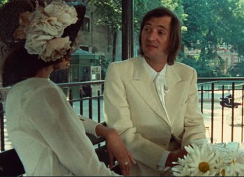 Movie still from “Celine and Julie Go Boating” (1974), directed by Jacques Rivette – A man and a woman sitting at a table; Medium shot, Over the shoulder angle