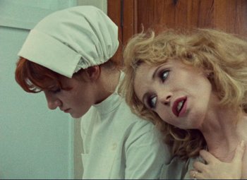 Movie still from “Celine and Julie Go Boating” (1974), directed by Jacques Rivette – A woman is holding a man's neck while they both look at each other; Close Up shot, Low angle