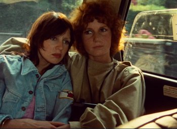 Movie still from “Celine and Julie Go Boating” (1974), directed by Jacques Rivette – Two women sitting in the back seat of a car; Close Up shot, High angle