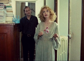 Movie still from “Celine and Julie Go Boating” (1974), directed by Jacques Rivette – A man and a woman standing next to each other in a room; Medium shot, Over the shoulder angle