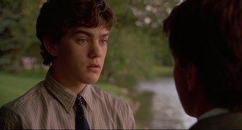 Movie still from “D3: The Mighty Ducks” (1996), directed by Robert Lieberman – A young man wearing a striped dress shirt and a tie; Close Up shot, Over the shoulder angle