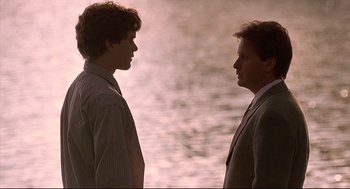 Movie still from “D3: The Mighty Ducks” (1996), directed by Robert Lieberman – Two men standing next to each other near a body of water; Medium shot, Over the shoulder angle