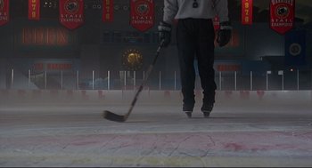 Movie still from “D3: The Mighty Ducks” (1996), directed by Robert Lieberman – A man holding a hockey stick on the ice; Wide shot, Low angle